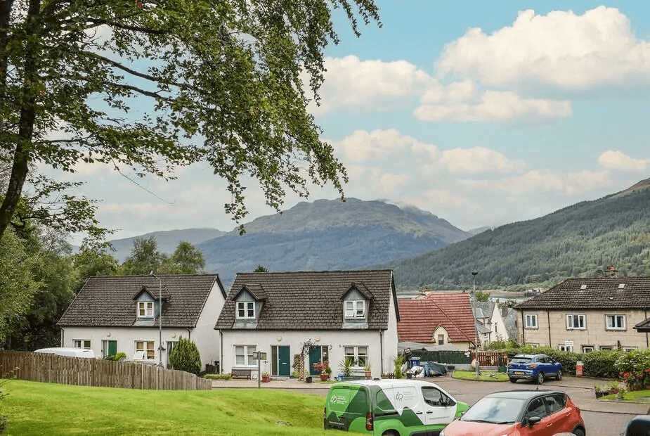 Beechwood white render cottage with dormer windows and slate roof, Arrochar hills behind