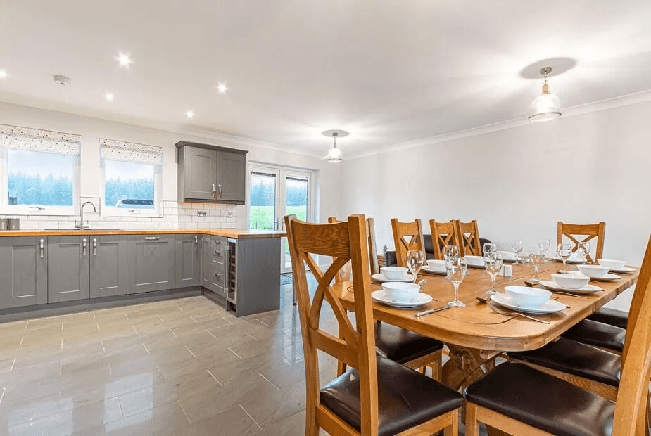 Open-plan kitchen and oak dining table set for ten with grey shaker units at Gartclach