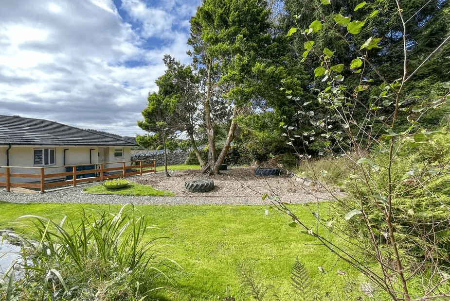 Hazel Apartment exterior with wooden terrace and mature trees, Aberfoyle