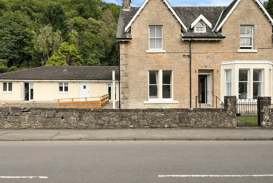 Holly Apartment is the modern white-rendered annex on the left, attached to a historic stone Victorian building, Aberfoyle