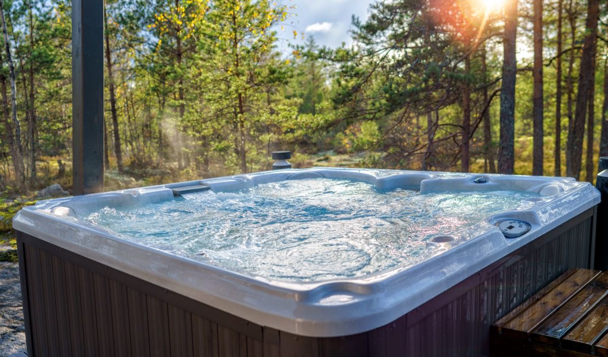 Hot tub lodge in a forest setting at sunset