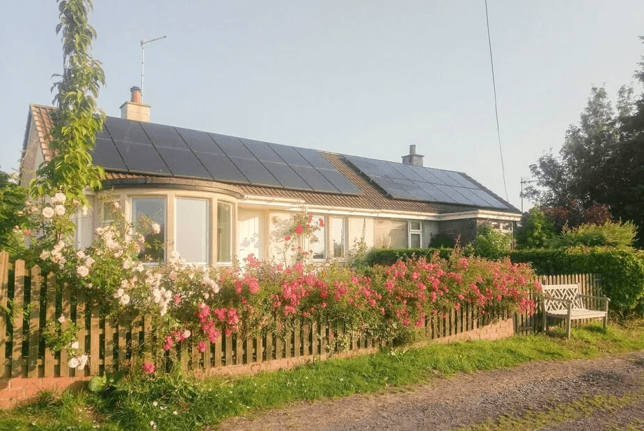 Puddingstone Cottage white bungalow with pink rose hedge in front, Gartmore